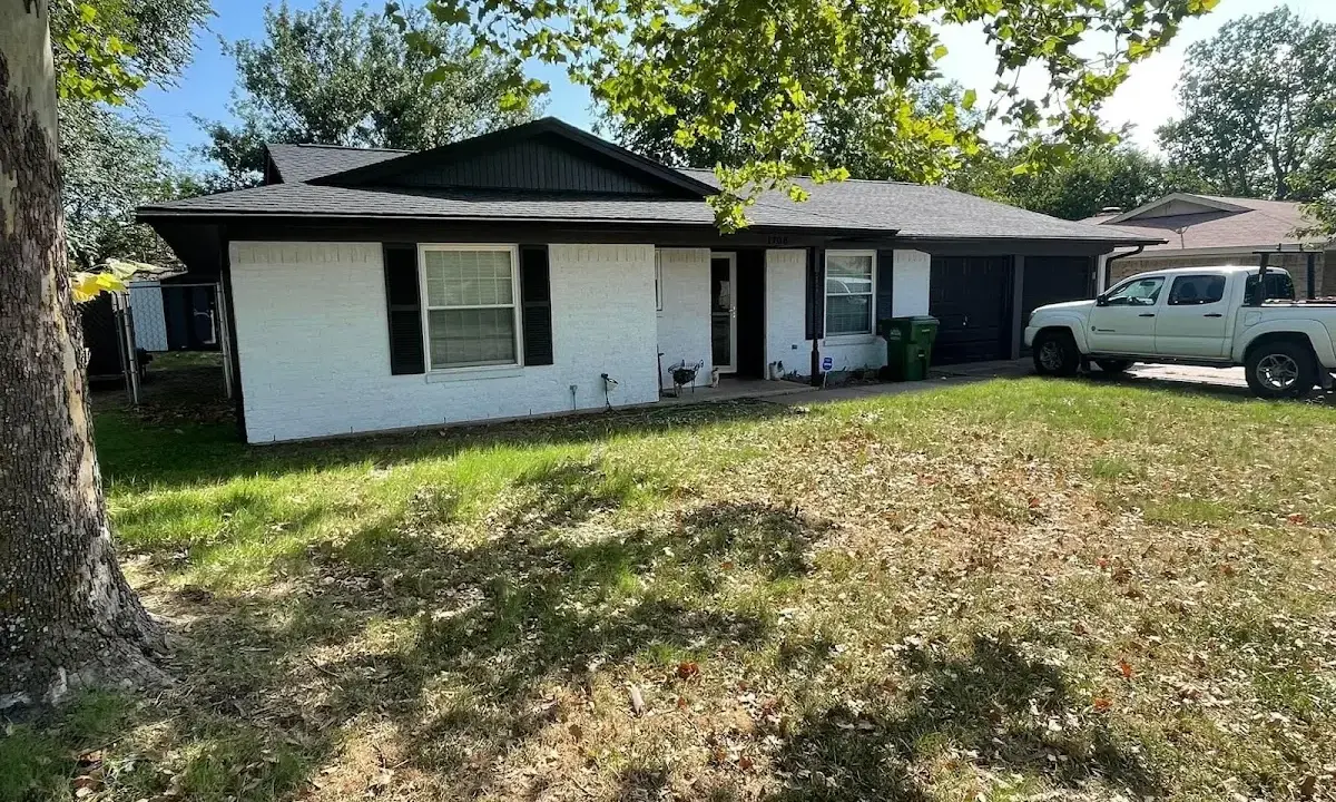 Professional roofing crew working on a residential roof in Acton